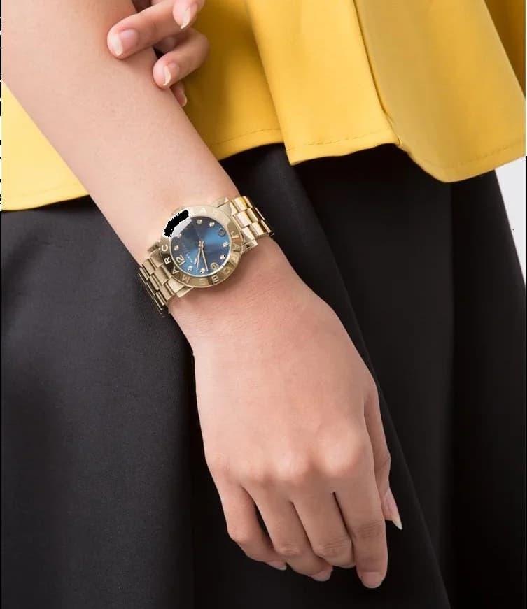 Cadran Marc Jacobs MBM3166 avec cadran bleu soleillé, index bâtons dorés et aiguilles fines pour une lisibilité élégante