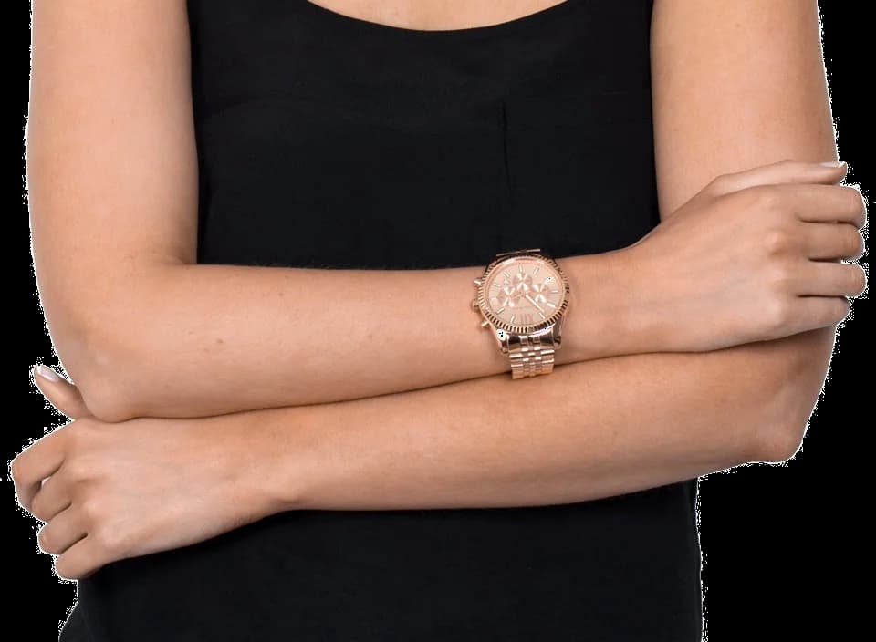 Cadran Michael Kors MK8319 au fond soleil rose poudré, index bâtons et chiffres romains, aiguilles dauphine dorées et guichet date à 6h